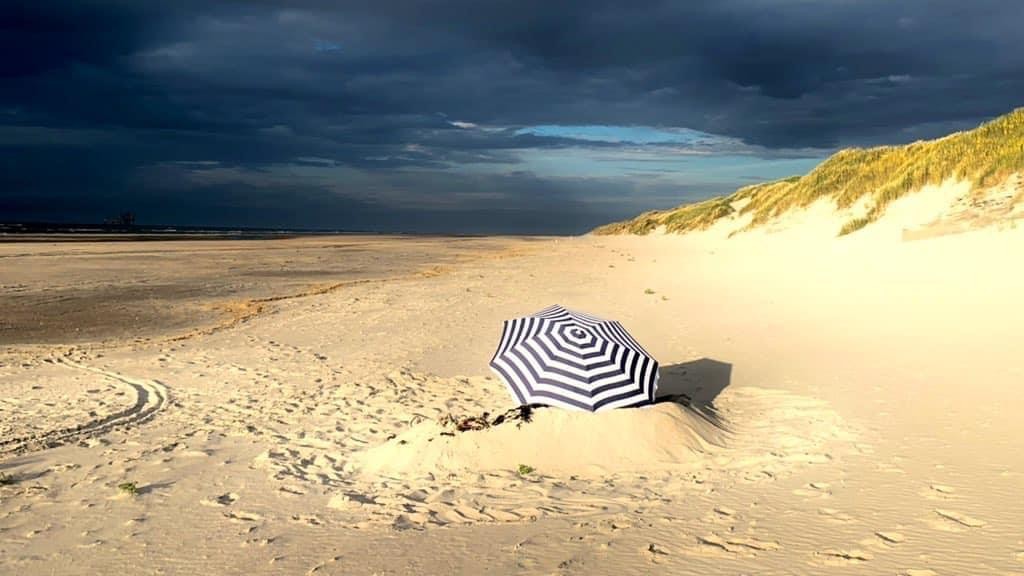 Strandparasol op strand Ameland storm op komst