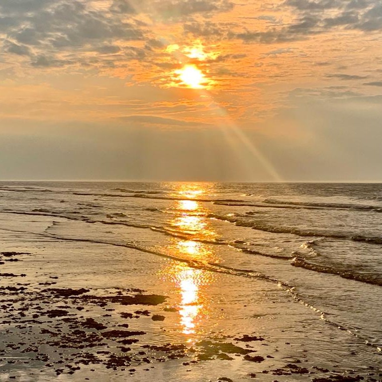 Zomeravond op Ameland Zomeravond op Ameland zonsondergang op het strand bij de branding van de zee