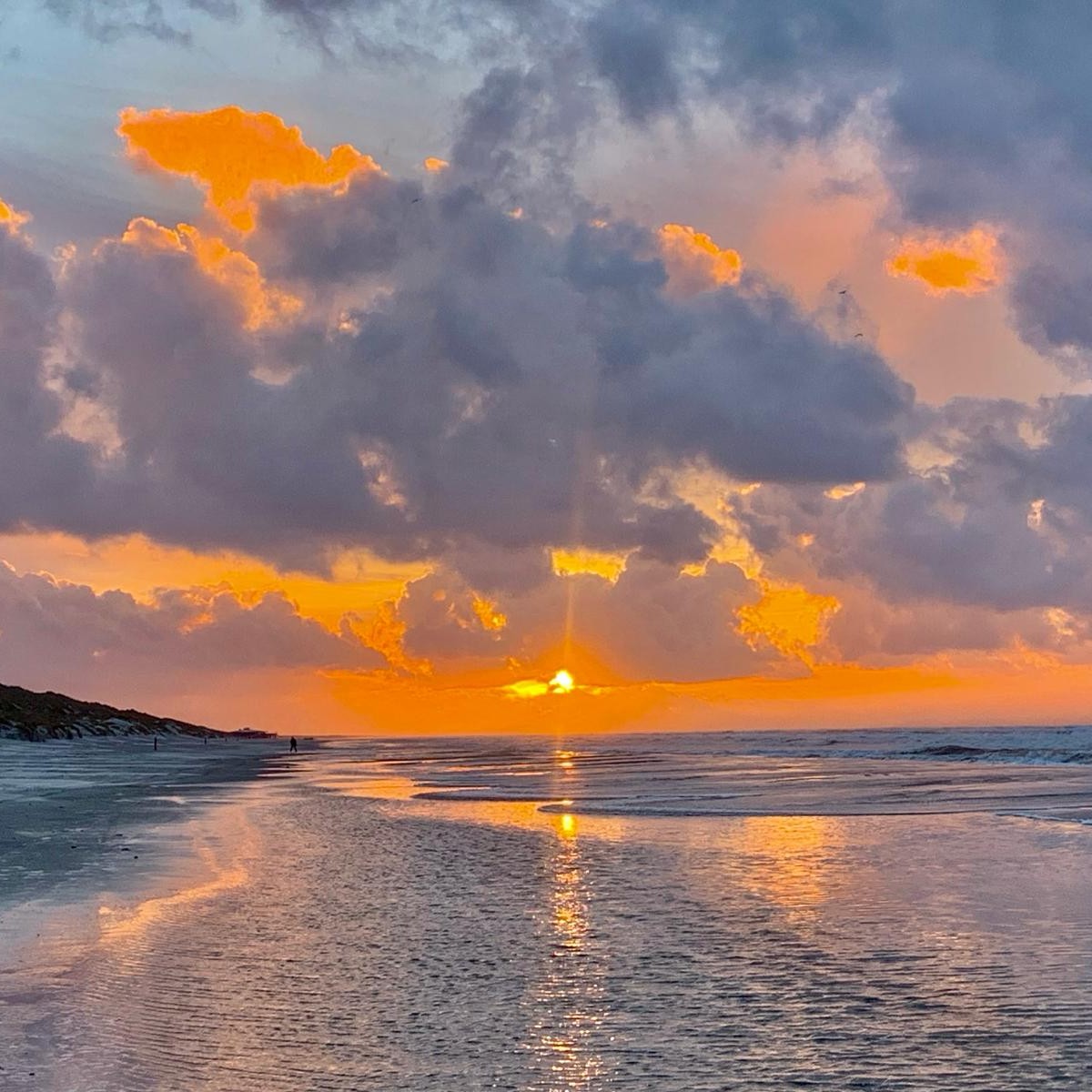 Zonsondergang op Ameland Zonsondergang op het Noordzee strand op Ameland zee en branding bij laag water zomeravond