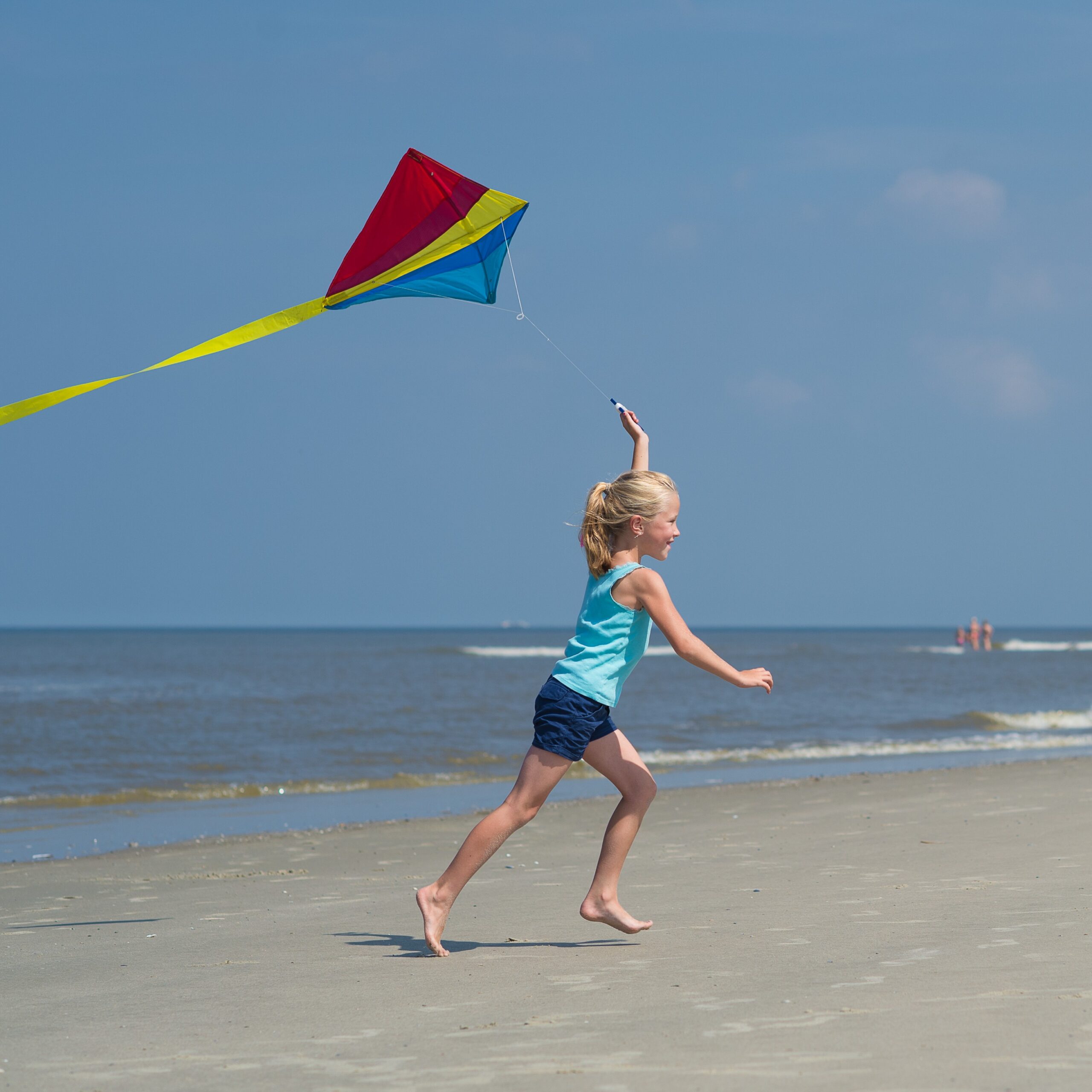 Vliegeren met kind op Ameland Vliegeren voor kinderen op het strand van Ameland. Spelen met vlieger. Vakantie op Ameland met gezin met kinderen.
